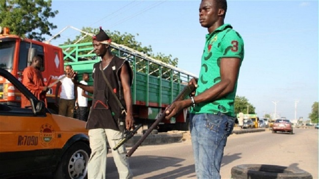 Civilians mount a roadblock in the northeastern city of Maiduguri, searching for Boko Haram suspects